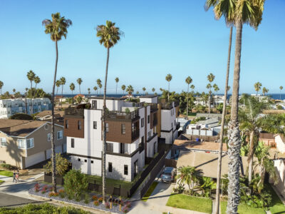 a new construction building with palm trees and ocean